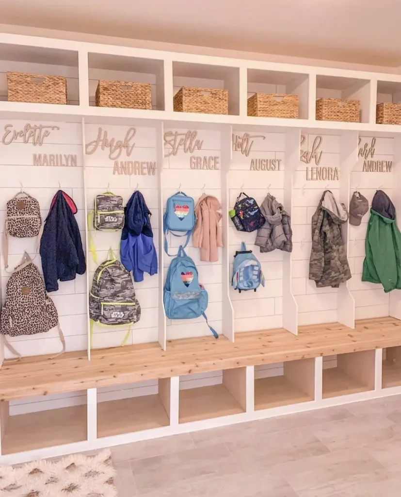 Built-in entryway cubbies with personalized sections, backpack hooks, woven baskets, and a long wooden bench.
