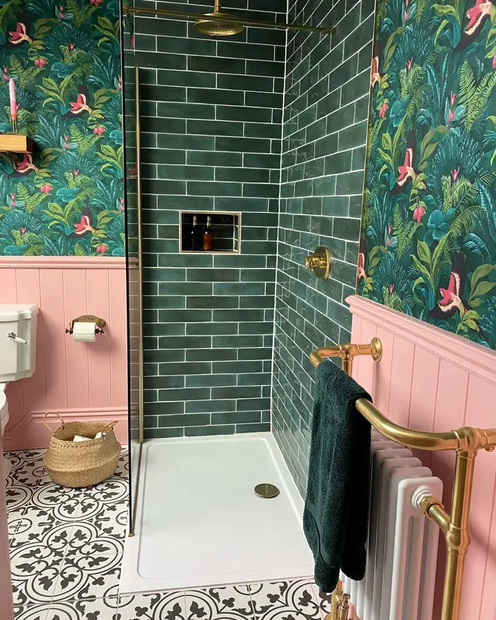 Emerald green herringbone tiled bathtub surround with olive curtain, brass rod and black-and-white floor tile
