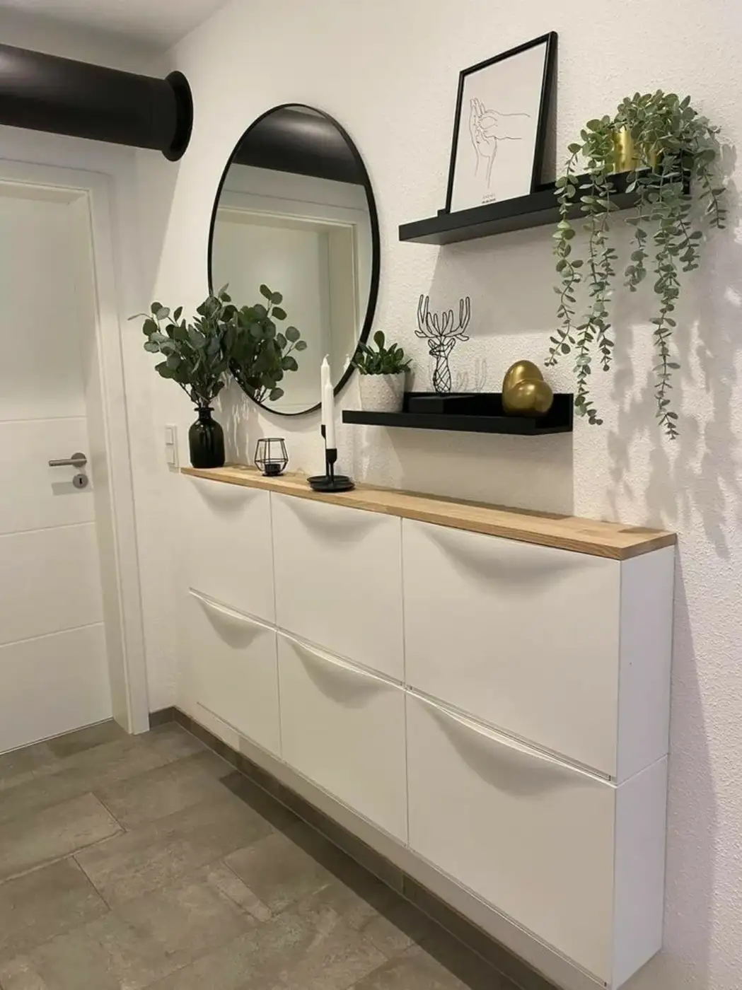 Wall-mounted shallow entryway cabinets with wood top, oval mirror, and floating shelves