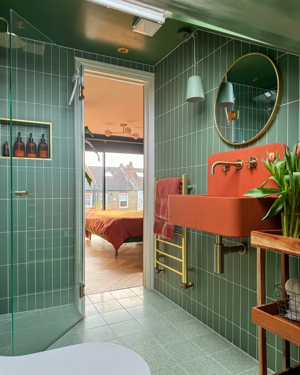 Eclectic green bathroom with patterned green and white walls, turquoise wall-mounted sink and ornate gold mirror