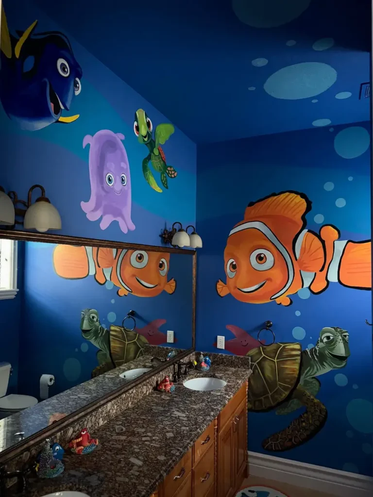 Children’s bathroom with a deep blue underwater mural featuring large orange fish, sea turtles, and colorful sea creatures.