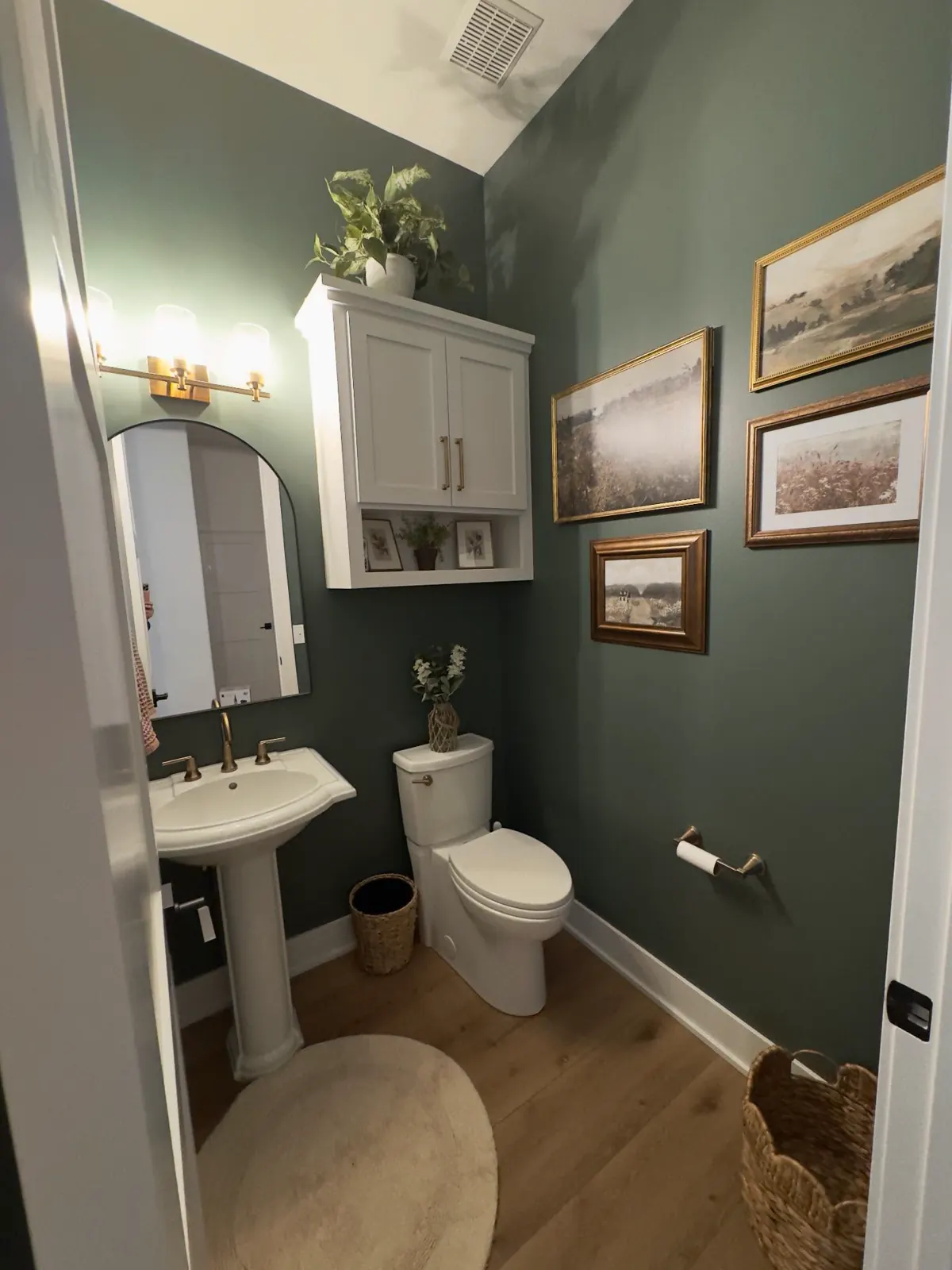 Dark green vertical tile bathroom with white clawfoot tub, wooden vanity, checkerboard floor and brass fixtures