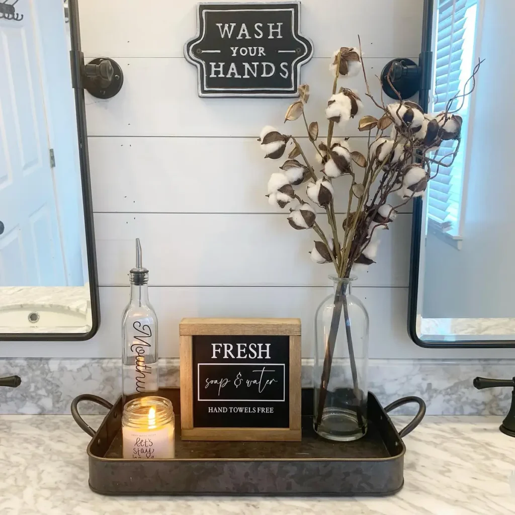 Dark metal farmhouse tray with a framed soap sign, candle, mouthwash bottle and tall cotton stems.