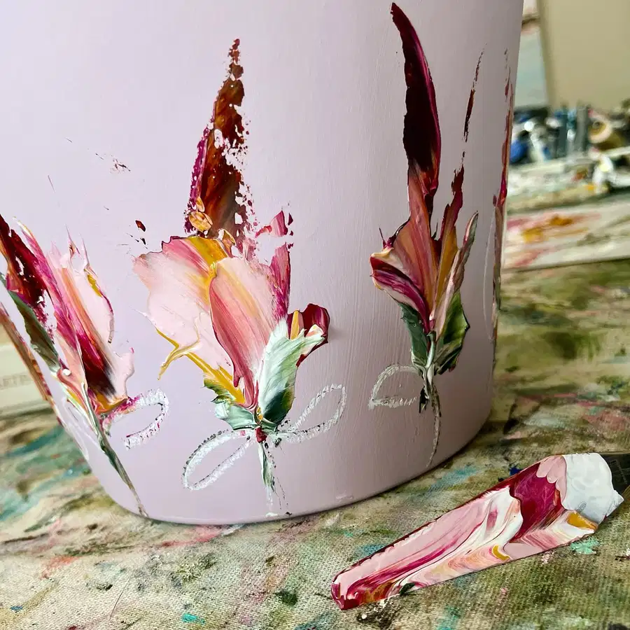 Pale pink flower pot painted with textured palette knife flowers in blush, burgundy, cream, and green