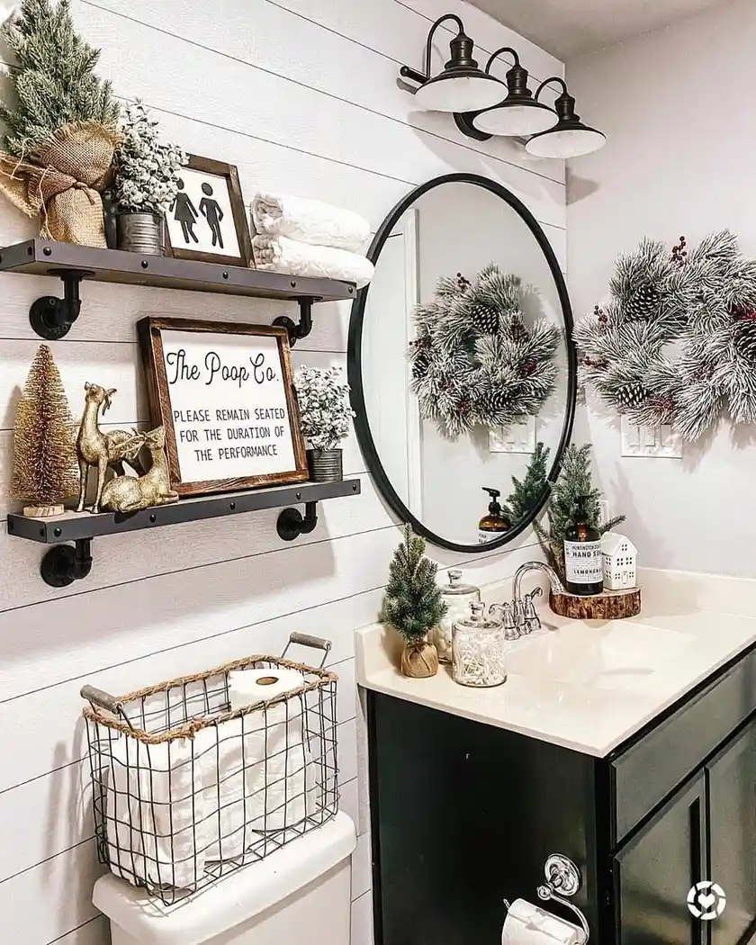 Modern farmhouse bathroom with white shiplap, black vanity, industrial shelves, oval mirror, wire basket, and seasonal evergreen decor