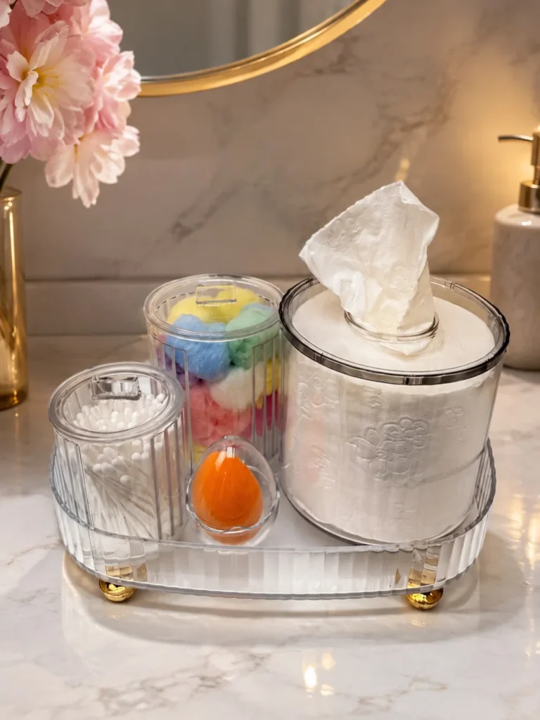Organized bathroom counter with matching clear containers holding tissues, cotton swabs, and other everyday bathroom essentials.