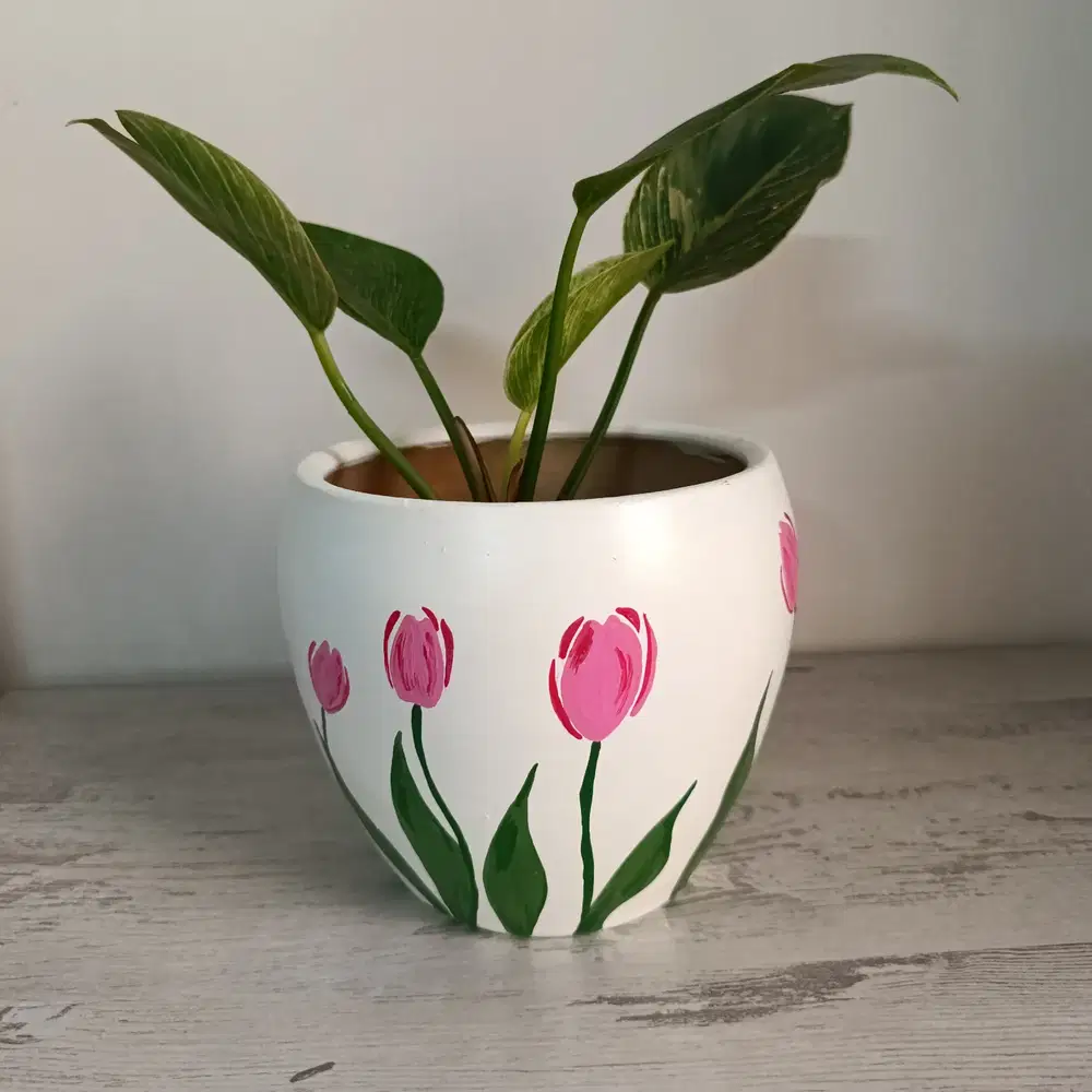White flower pot hand painted with simple pink tulips and green stems