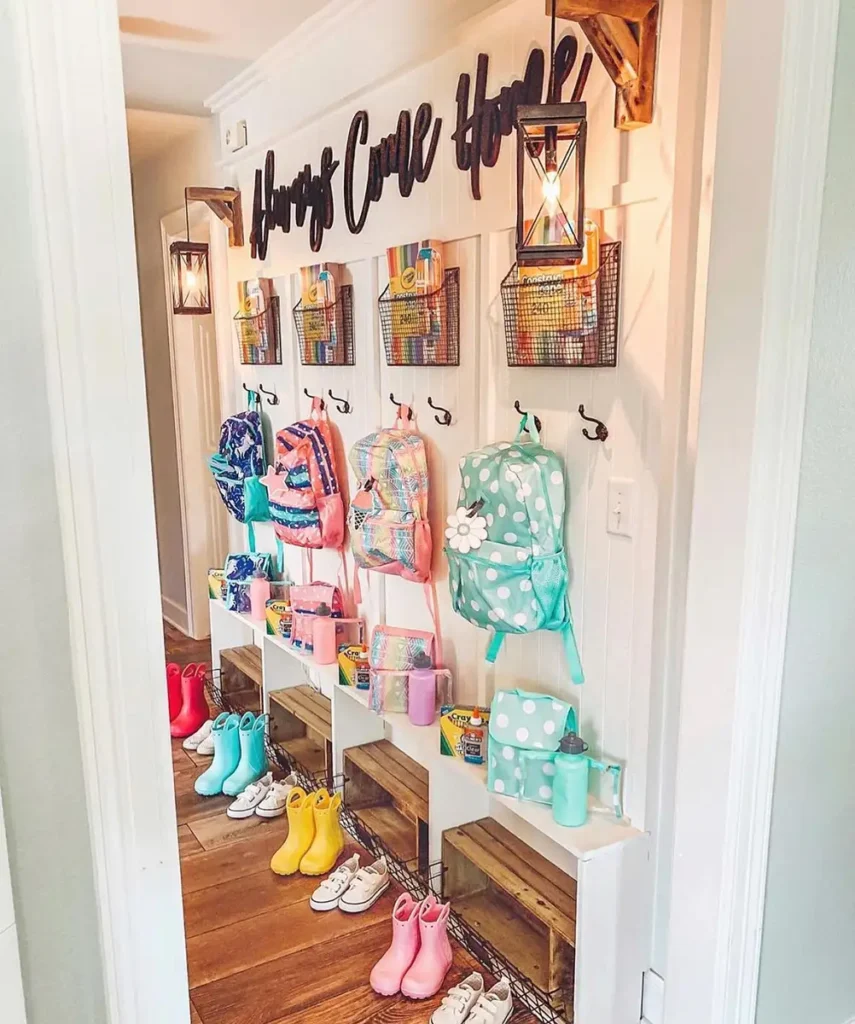 Long family school gear wall with backpack hooks, wire baskets, bench cubbies, lunch supplies, and shoes.
