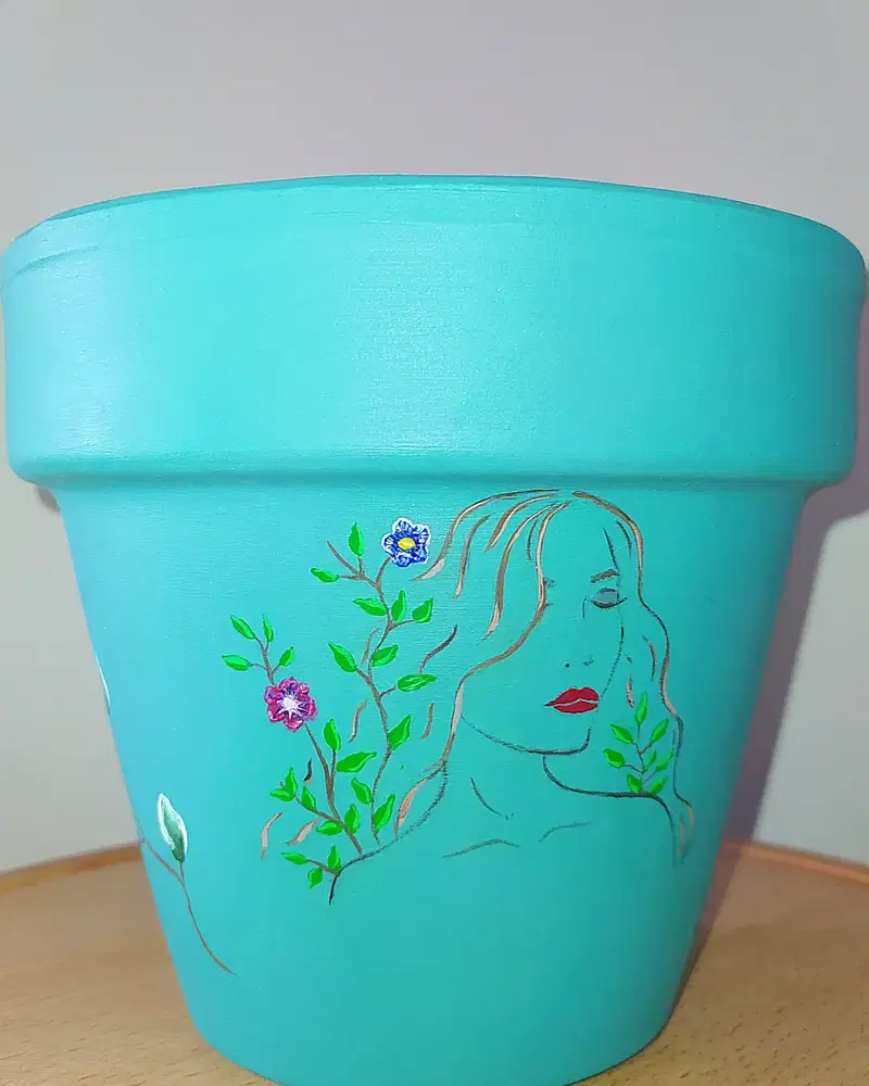 Aqua flower pot featuring a delicate painted woman portrait surrounded by green vines and tiny flowers