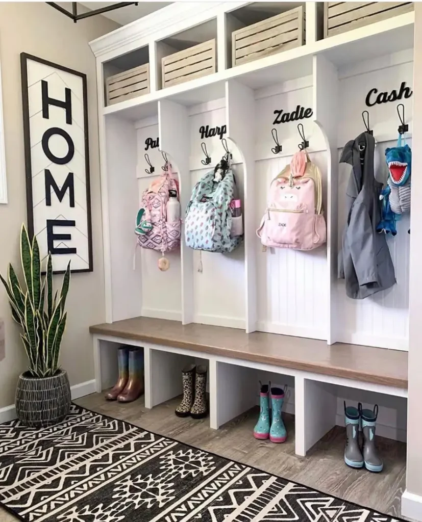 Built-in mudroom with personalized bays, backpack hooks, upper baskets, bench, and individual shoe cubbies.