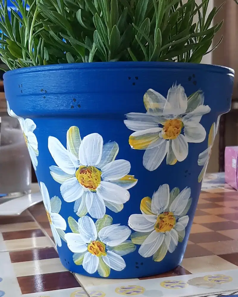 Deep blue flower pot hand painted with loose white daisies and textured yellow centers