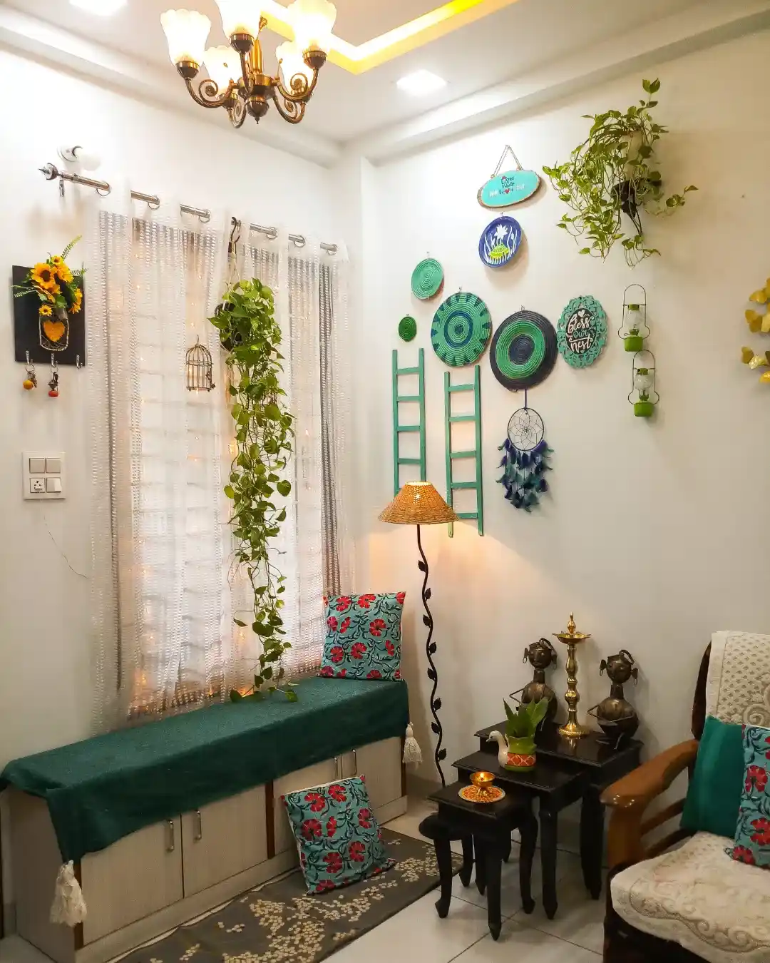 Cozy living room corner with hanging plants, floor lamp, teal bench, wall decor, and small nesting tables