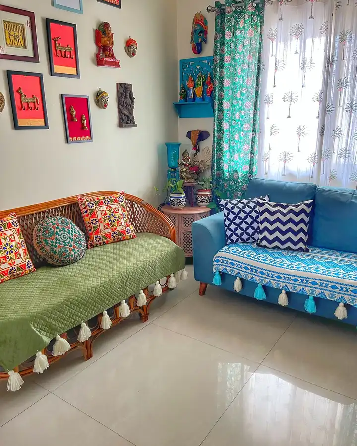 Colorful eclectic living room with blue and green sofas, patterned cushions, cane furniture, and collected wall decor.