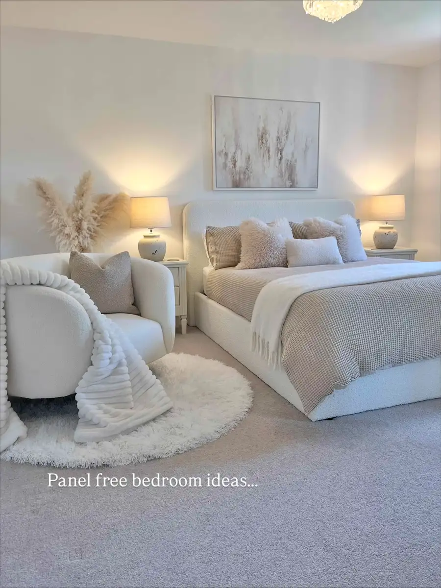 Soft neutral bedroom with a boucle bed, plush pillows, fluffy rug, pampas grass, and warm bedside lighting.