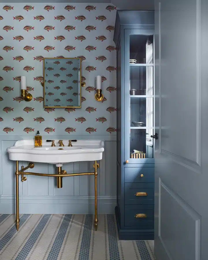 03 Narrow blue floor-to-ceiling bathroom cabinet beside a sink with glass doors and drawers