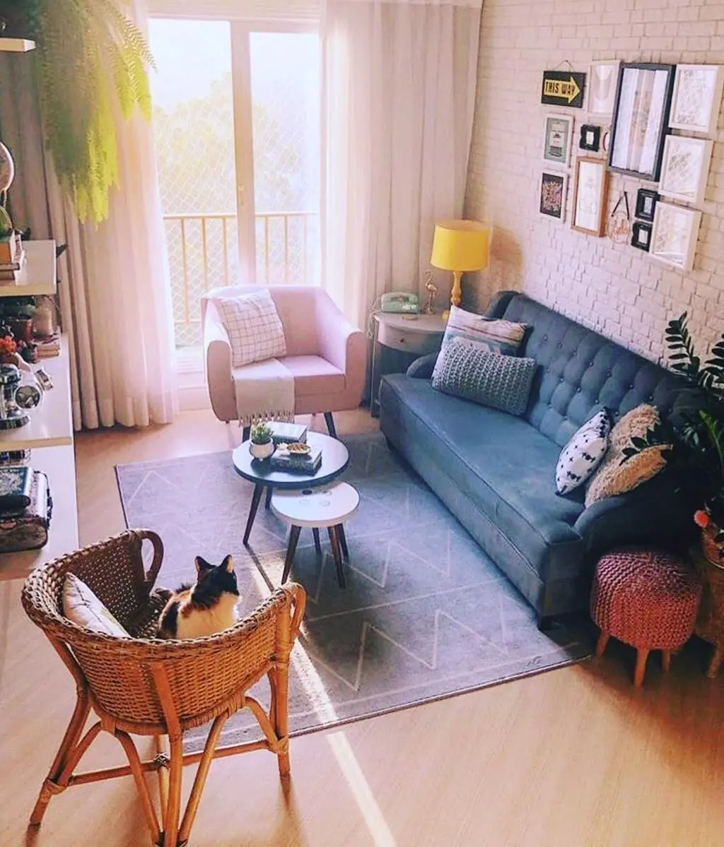 Small narrow living room with a dark charcoal sofa, pale rug, white pillows, and slim coffee table