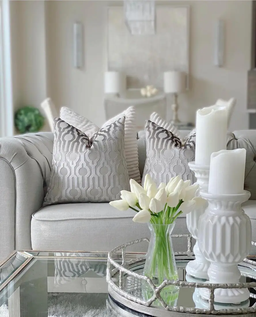 White coffee table tray with pillar candles, ceramic candleholders, clear vase, and white tulips