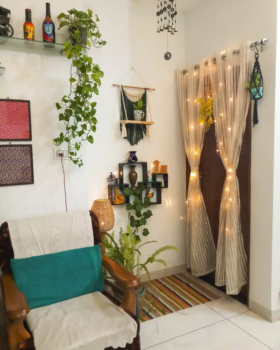 Colorful living room corner with wooden chair, hanging plants, wall shelves, fairy lights, and teal accents