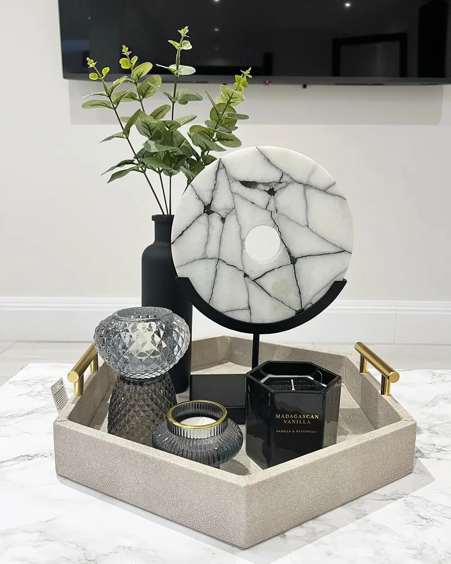 Modern coffee table tray with black vase, marble-look decor, candles, gold accents, and greenery
