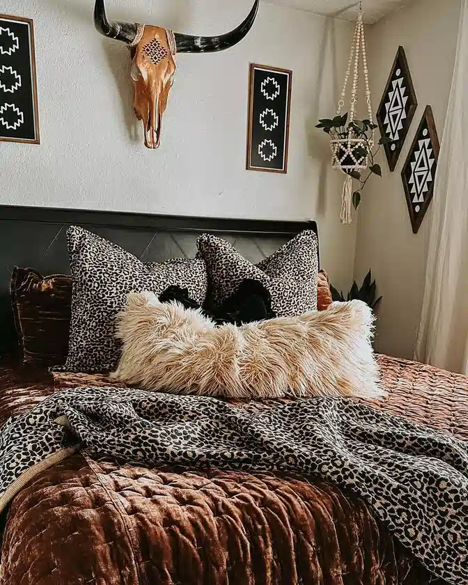Leopard print pillows and throw layered over rust bedding with a cream shaggy cushion