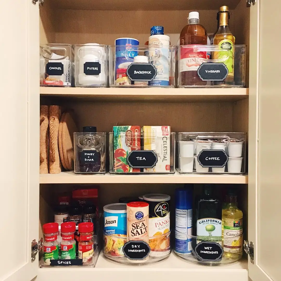 Deep pantry shelves with turntables for bottles and seasonings plus clear bins for tea, coffee, and pantry backstock