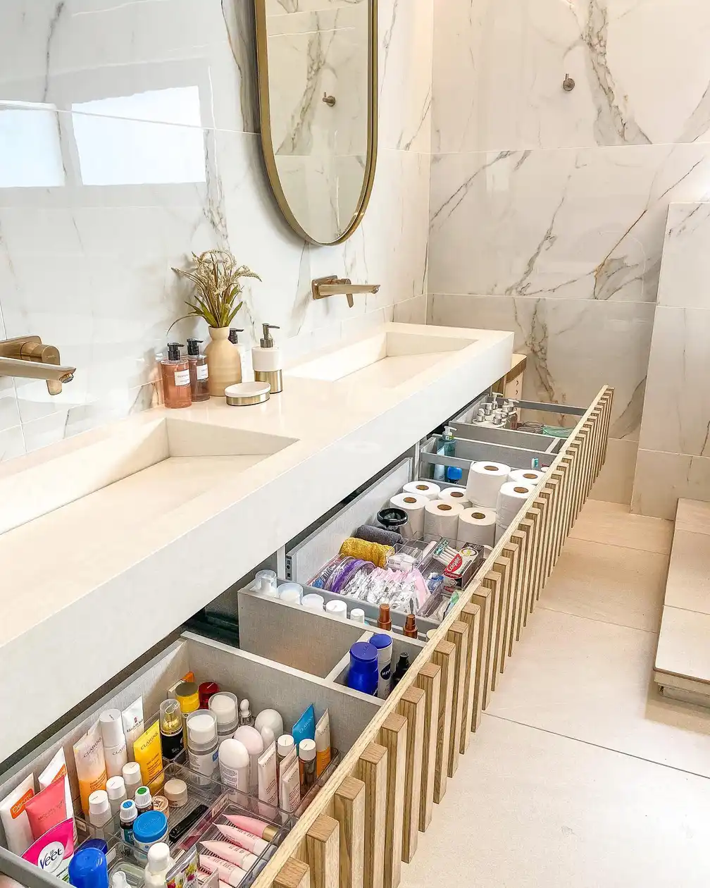 Bathroom vanity with deep pull-out drawers divided into sections for toiletries, skincare, bottles, and toilet paper