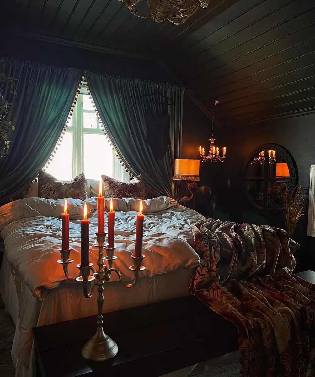 Dark moody bedroom with painted ceiling, heavy curtains, warm lamps and candlelight