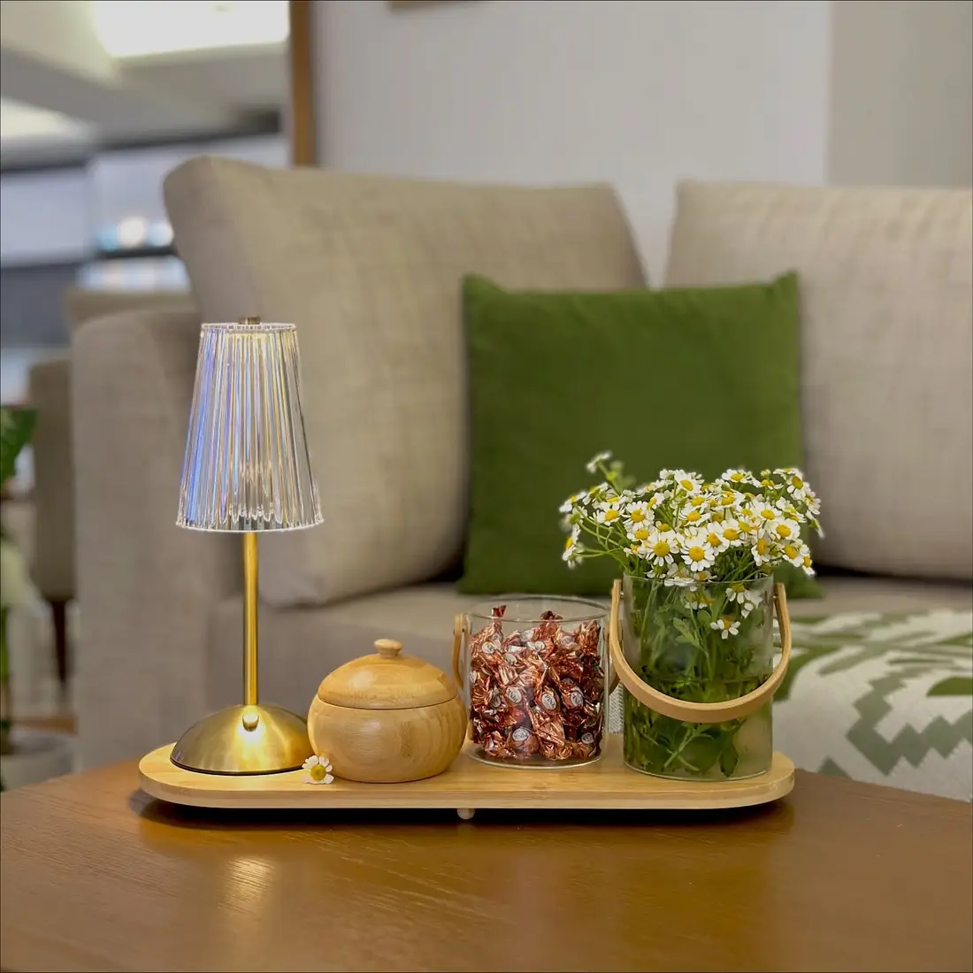 Slim coffee table tray styled with a small lamp, flowers, lidded bowl, candy jar, and decorative accessories
