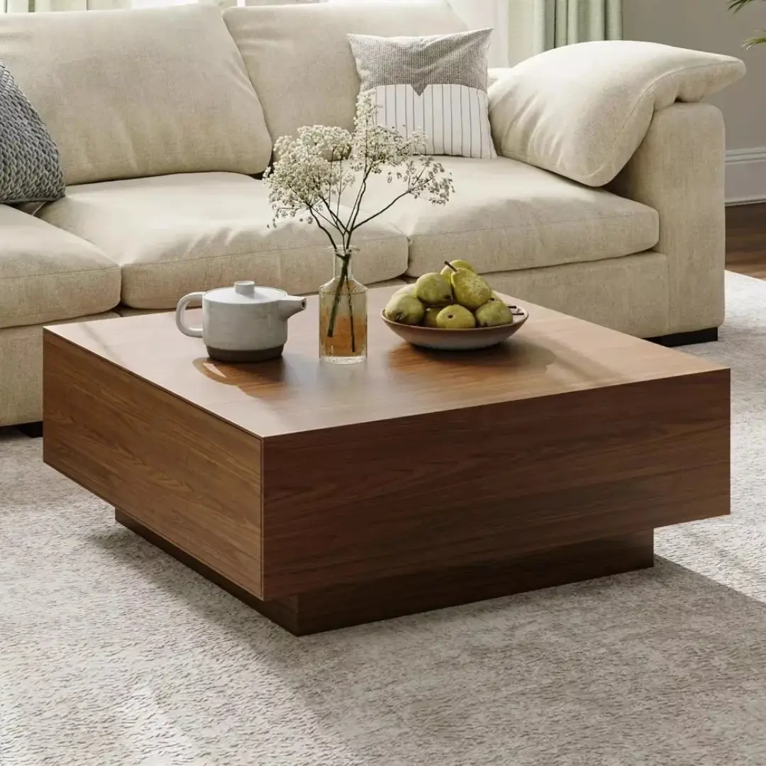 Wood coffee table styled with a white teapot, bowl of green pears, and simple flowers in a glass vase