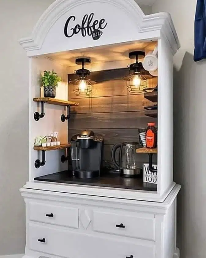 White hutch converted into a farmhouse coffee bar with dark wood backing, cage lights, small side shelves, kettle, and coffee maker