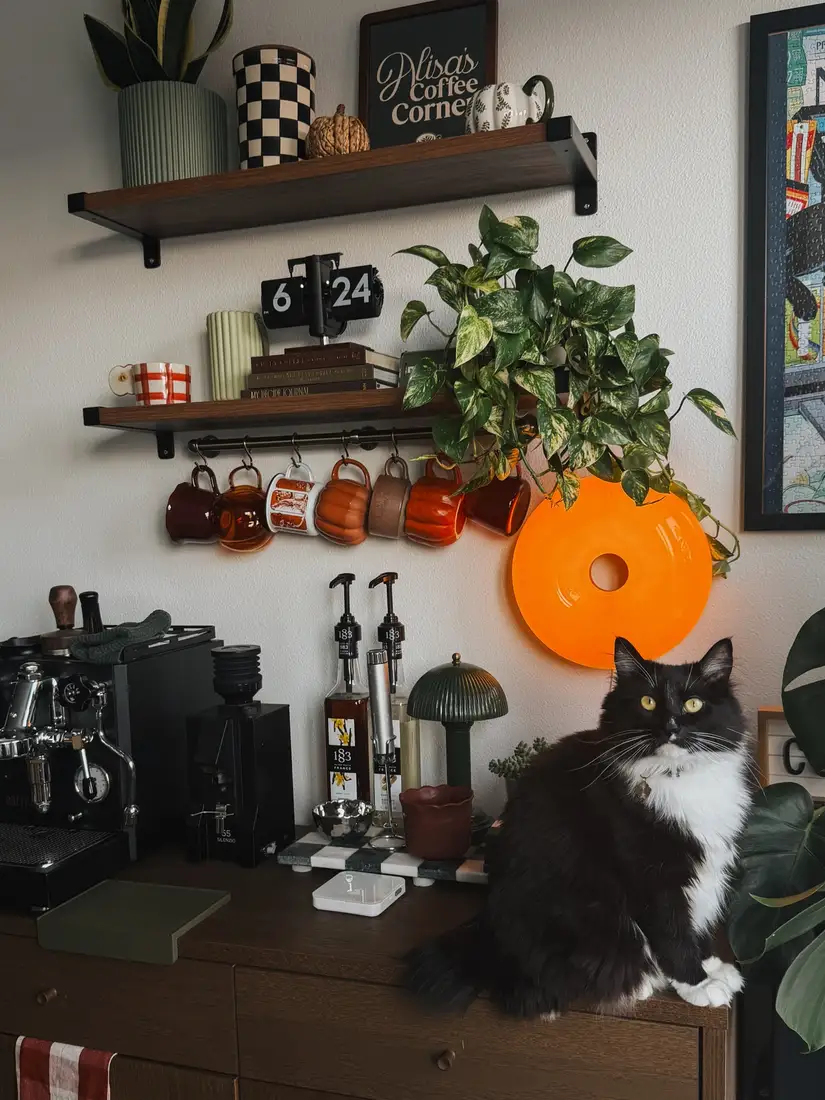 Moody fall coffee station with black espresso machine, burnt orange mugs, dark wood shelves, plants, and glowing wall light
