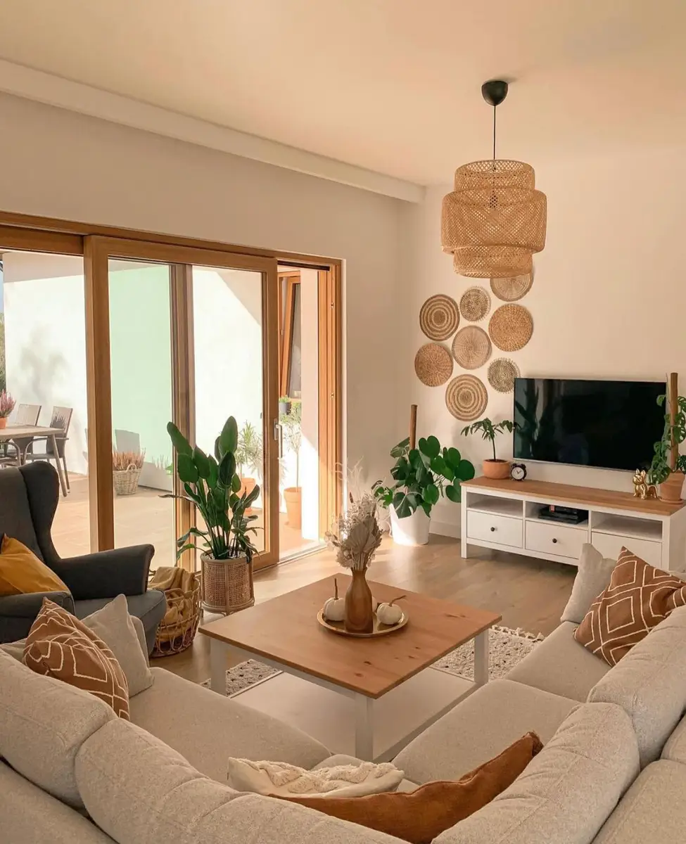 Airy TV living room with a wood coffee table, low console, woven wall baskets, sliding wood doors, and indoor plants.