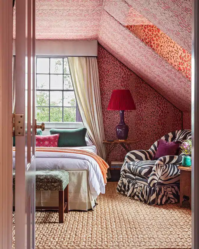 Leopard print wallpaper covering a bedroom wall and sloped ceiling above mostly white bedding