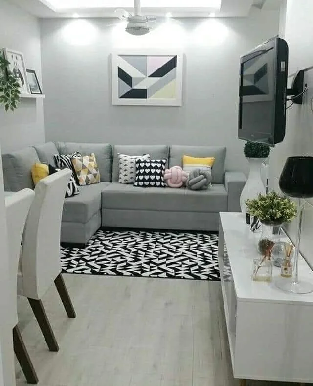 Narrow living room with blue floral wallpaper, simple sofa, neutral rug, small side table, and brass floor lamp