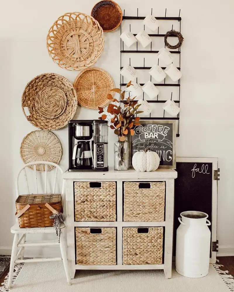 Fall coffee station with woven wall baskets, wicker storage drawers, white mugs, rusty leaves, and a white pumpkin
