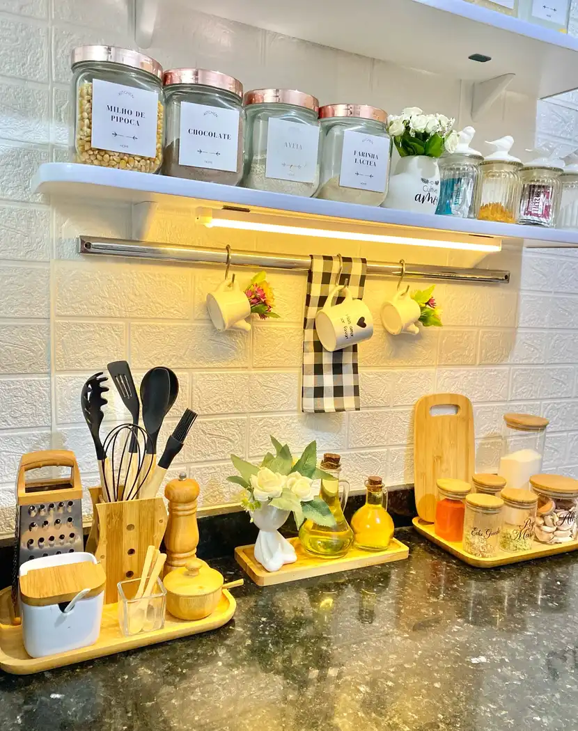 Organized kitchen counter with cooking utensils, oil bottles, seasonings, labeled jars and warm wood accents