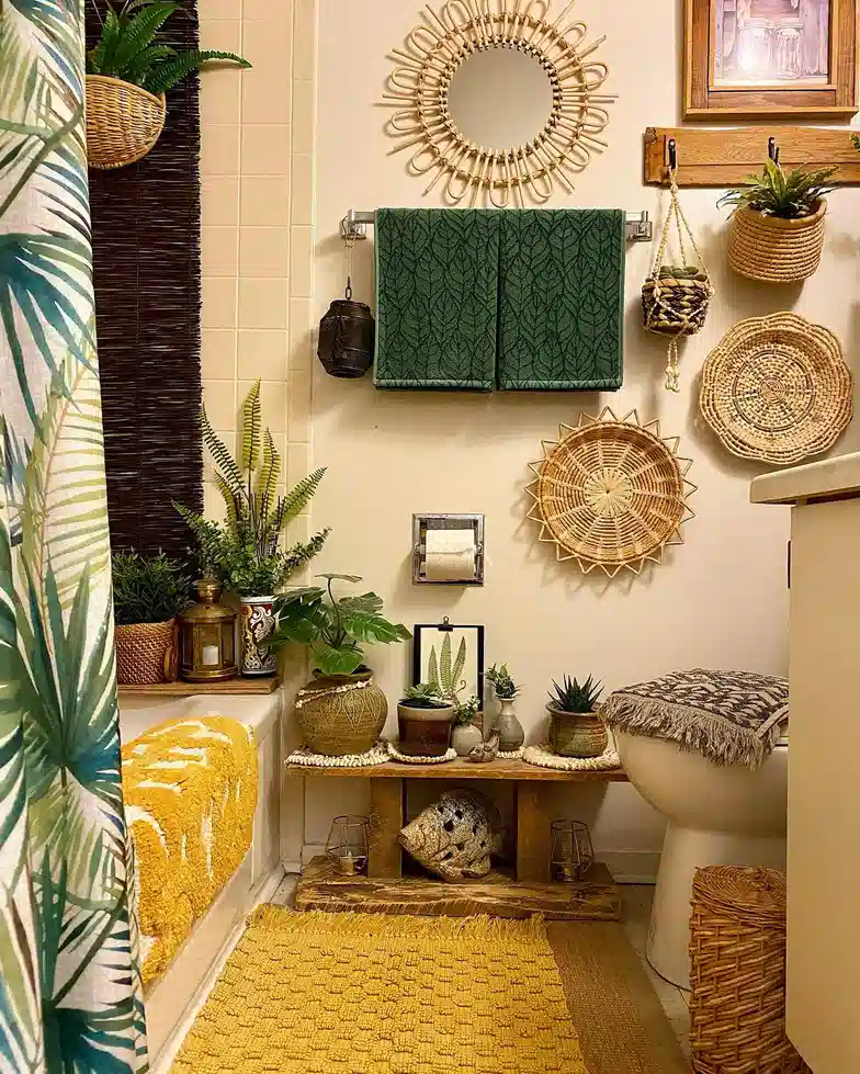 Boho bathroom with woven wall baskets, rattan mirror, hanging plants, leafy shower curtain, and mustard rug