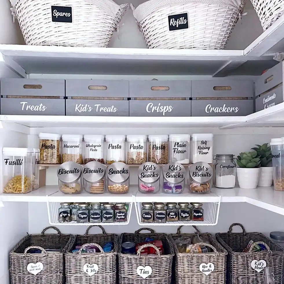 Deep pantry with hanging under-shelf spice racks, clear food containers, and baskets for additional storage