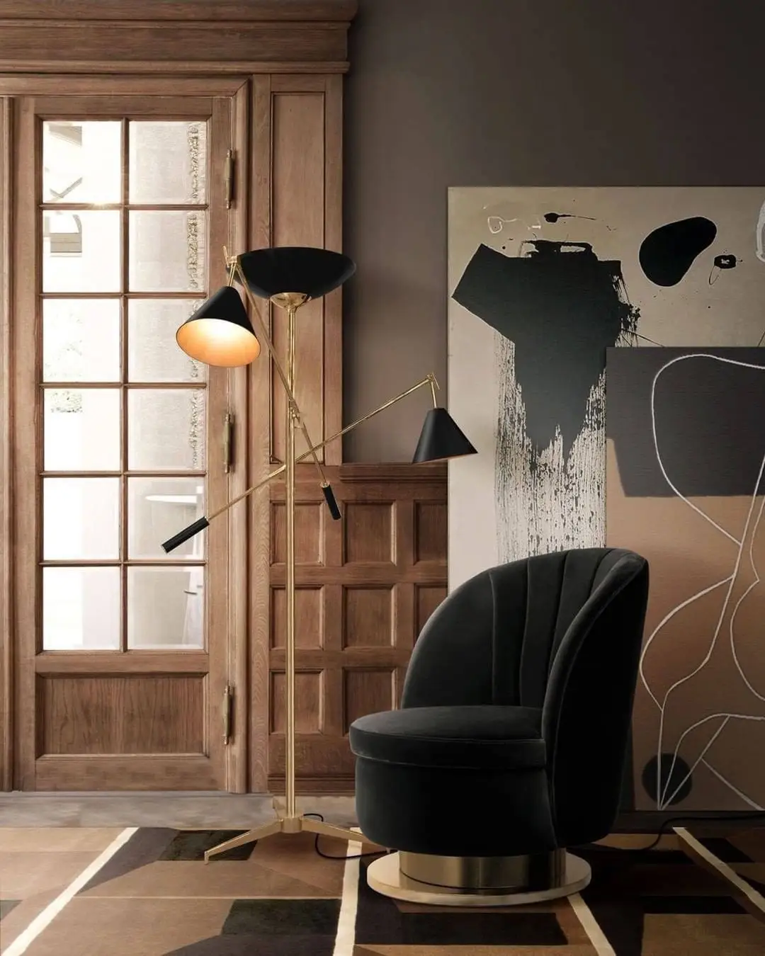 Modern living room corner with black accent chair, sculptural brass floor lamp, and oversized abstract artwork