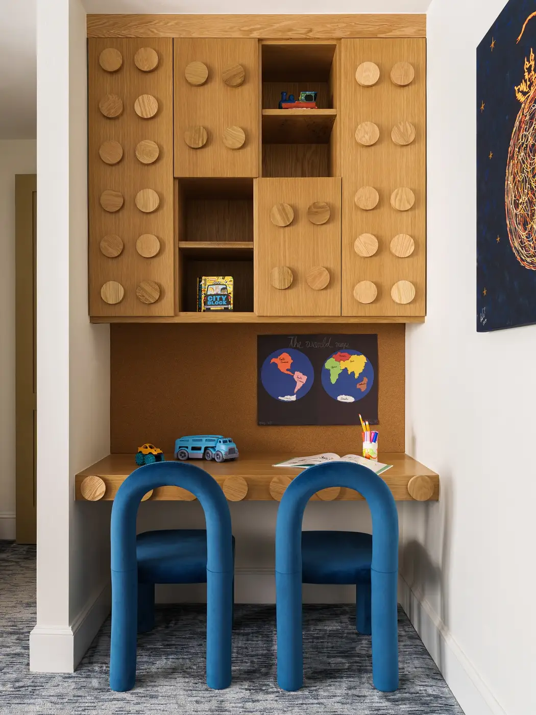 Two-seat built-in homework desk with large corkboard wall, drawers, and overhead cabinets