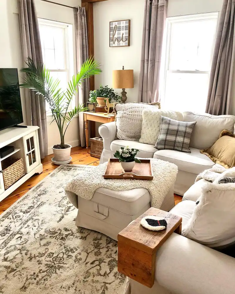 Cozy sectional living room with a large ottoman used as a coffee table with a wooden tray and flowers.
