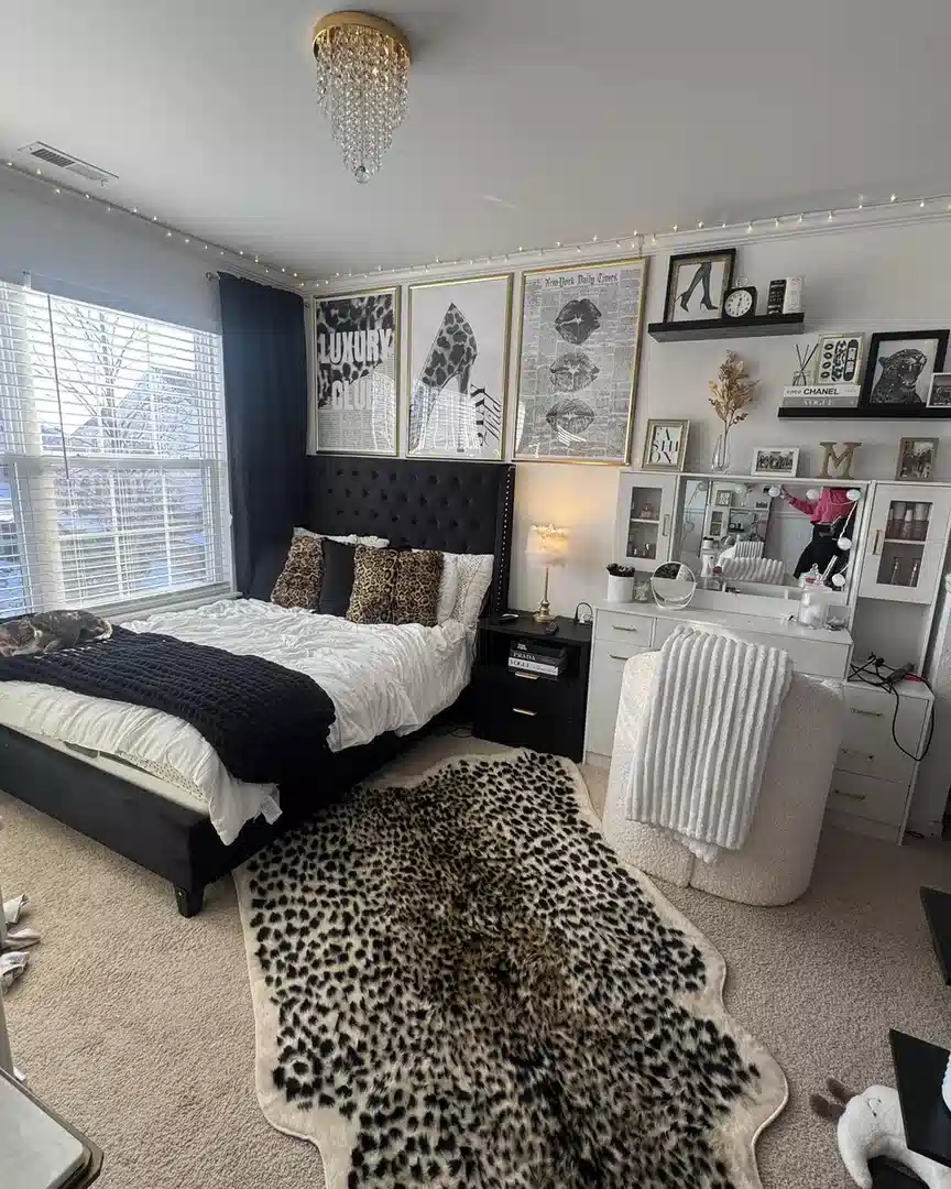 Large leopard print rug beneath a black and white bedroom with matching leopard pillows
