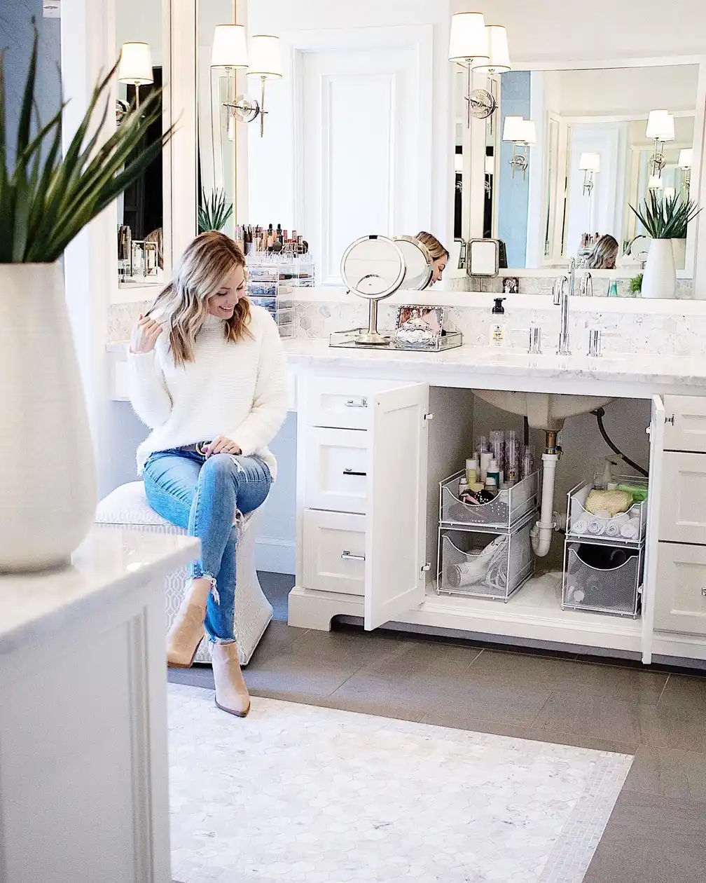 Under bathroom sink organized with two matching pull-out storage towers for bottles, towels, and bathroom supplies