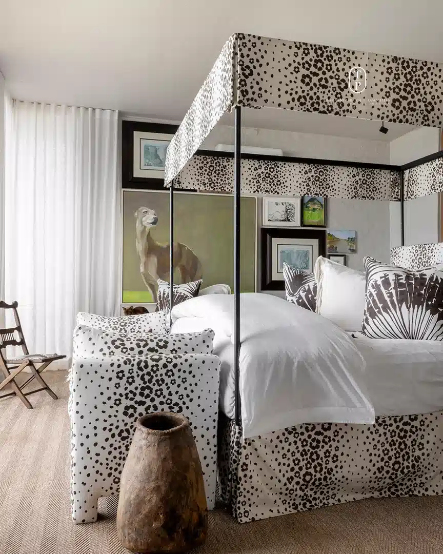 Black and white leopard print upholstered bed frame and canopy with plain white bedding