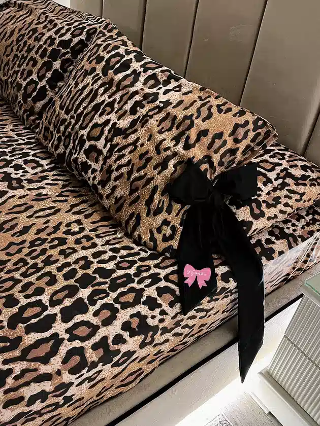 Tan and black leopard print bedding decorated with an oversized black bow