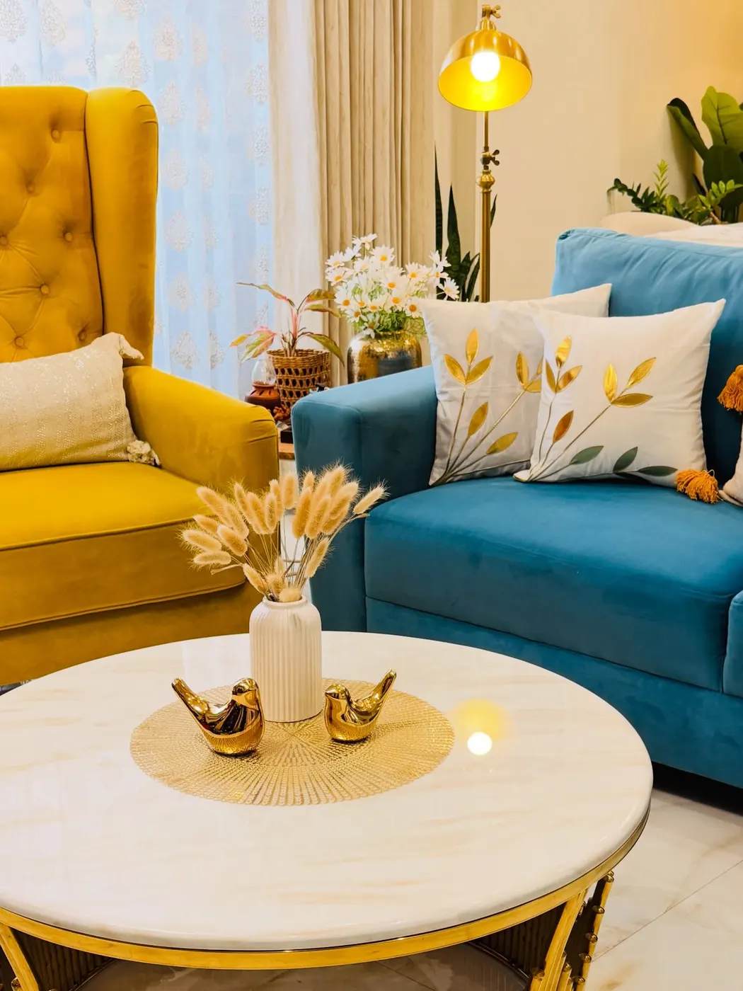 Coffee table with cream vase, dried stems, gold bird figurines, and small metallic accents