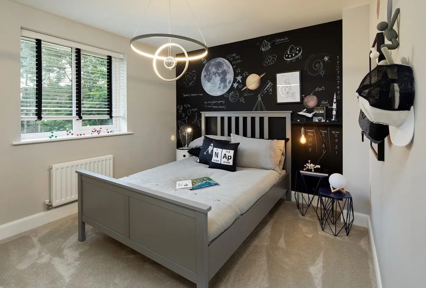 Dark bedroom wall covered with hand-drawn planets, stars, moons, and orbital line details