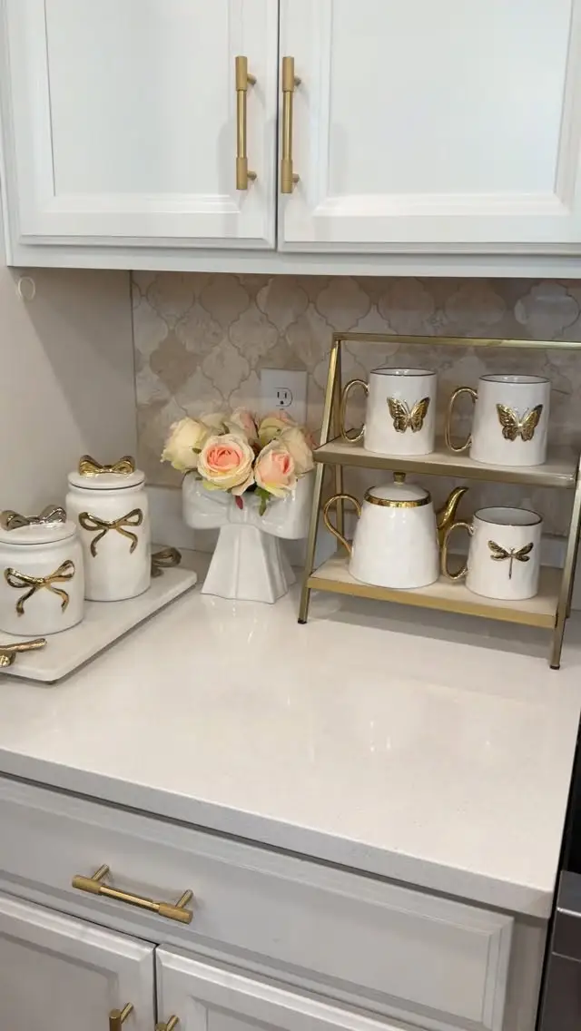 Small tea station with gold tiered stand, white mugs, teapot, matching canisters and pastel flower bouquet