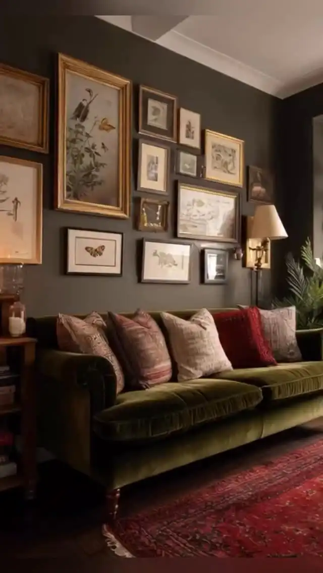 Vintage living room with olive velvet sofa, red rug, botanical gallery wall, and faded patterned cushions