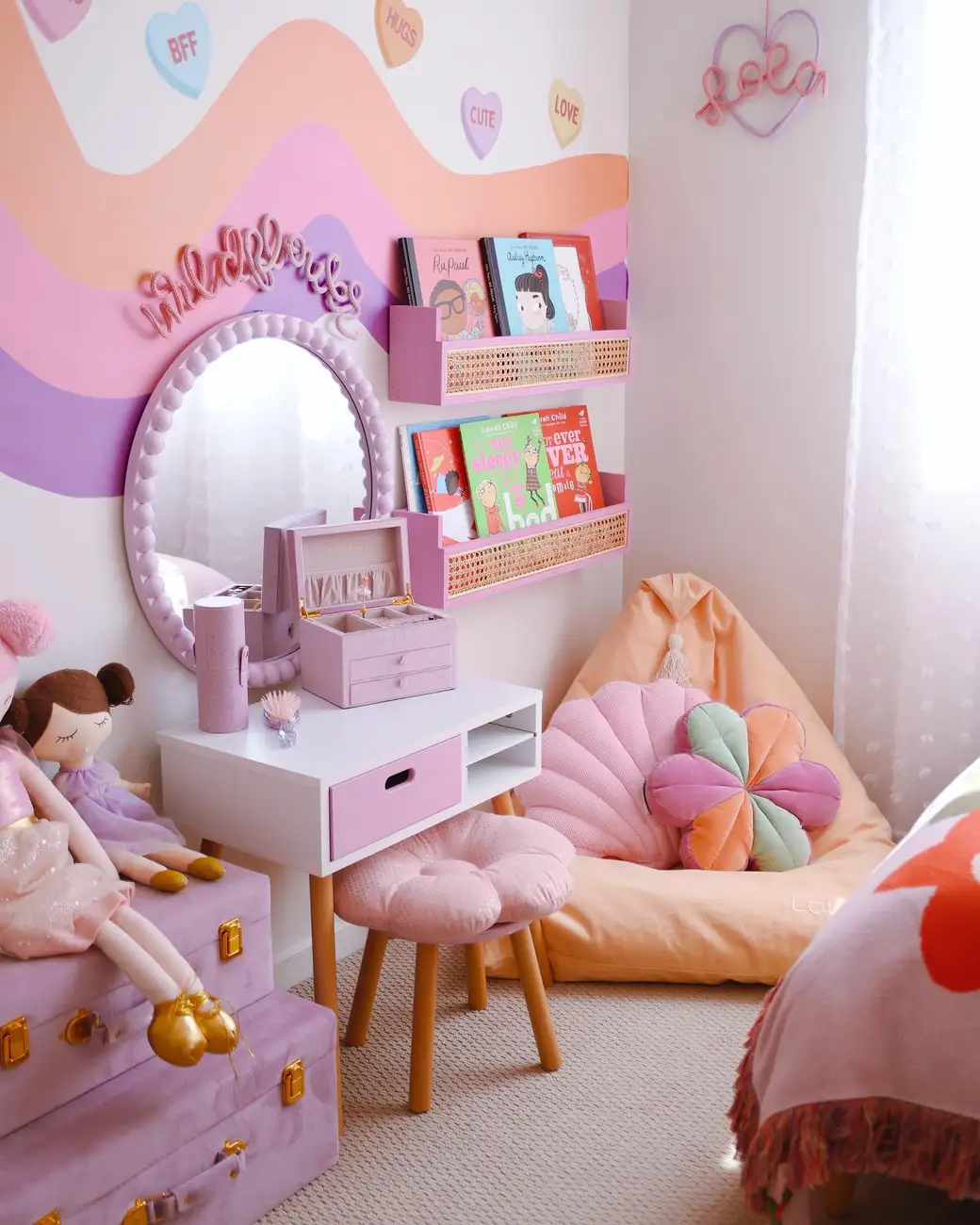 Girls reading corner with peach beanbag, wall-mounted book racks, small desk, mirror, and pink storage